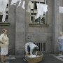 Drei Waschfrauen in Schürzen und gemusterten Röcken sind da zu Gange. Sie hängen weiße Wäsche auf, die schnell ergraut.<br />25.5.2010