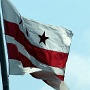 Die Flagge des Districts of Columbia wurde am 15. Oktober 1938 durch eine Kommission des US-Kongresses der Vereinigten Staaten eingeführt. Die heutige Version wurde von Charles A. R. Dunn gestaltet (nach einem Entwurf von 1921).<br />Die Flagge besteht aus drei roten fünfzackigen Sternen über zwei roten parallel verlaufenen Streifen, die über die ganze Breite verlaufen. Das Grundtuch ist weiß. Das Verhältnis beträgt 3:5.<br /><br />Wappen George Washingtons (stilisiert)<br />Sie basiert auf einem Banner mit dem Wappen der Familie George Washingtons, dem Namensgeber der Stadt Washington, D.C. Es stammt aus England (County Durham) und reicht zurück bis ins Jahr 1592.