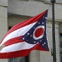 Die Flagge wird auch Ohio Burgee genannt. Das blaue Dreick steht für die Hügel und Täler des Staates, die Streifen sind Straßen und Flüsse.<br />13 Sterne dürfen natürlich nicht fehlen, hier sind noch 4 Sterne etwas abgesetzt, die Ohio als 17. Staat symbolisieren.<br />Der rote Kreis auf weissen Untergrund stehen für das O in Ohio. Daher kommt auch der Spitzname Buckeye State.<br />Die Flagge ist nicht rechteckig - als weltweit einzige Staatsflagge neben der Nepals - sondern hat am äusseren Ende einen Einschnitt
